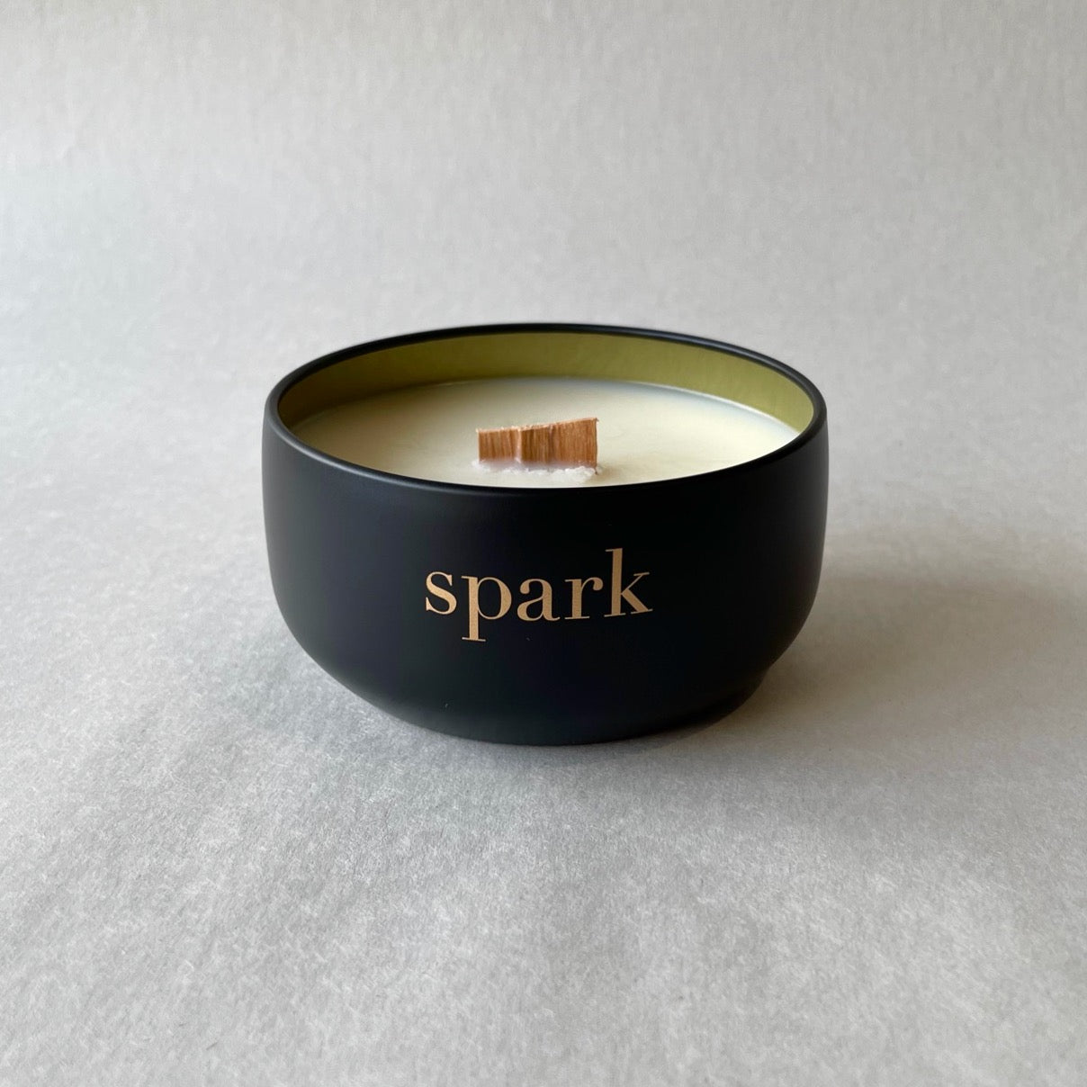 Close-up of gold interior inside an 8oz matte black tin custom candle with a real wood wick