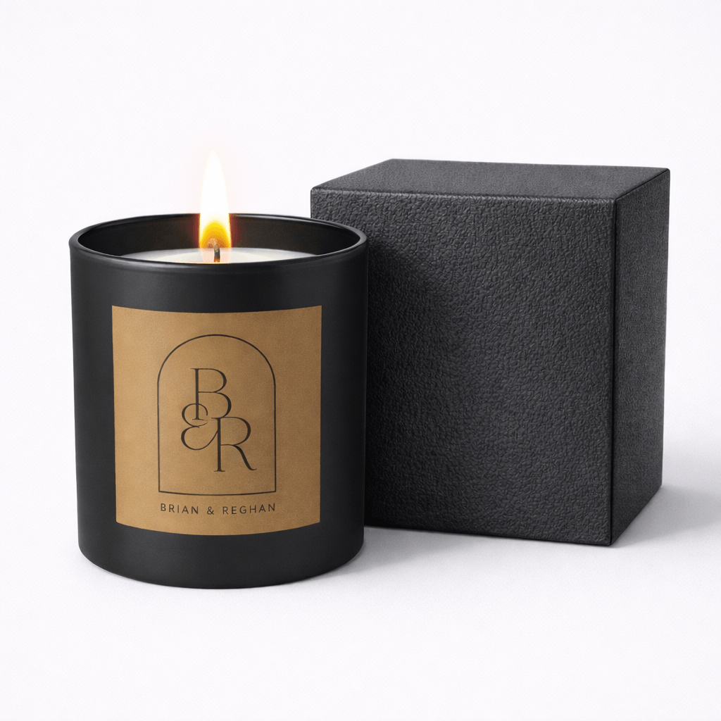 Black candle with a brown label and matching black box on a white background