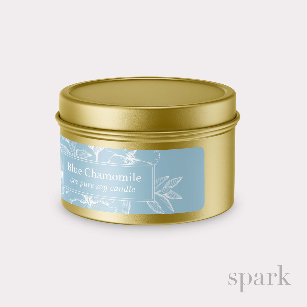 Candle tin labeled 'Blue Chamomile' with a gold lid on a light gray background