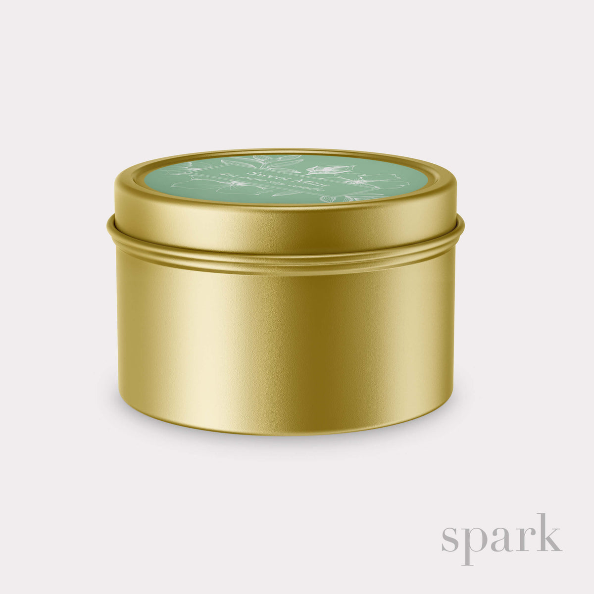 Gold cylindrical tin with a green lid on a light gray background
