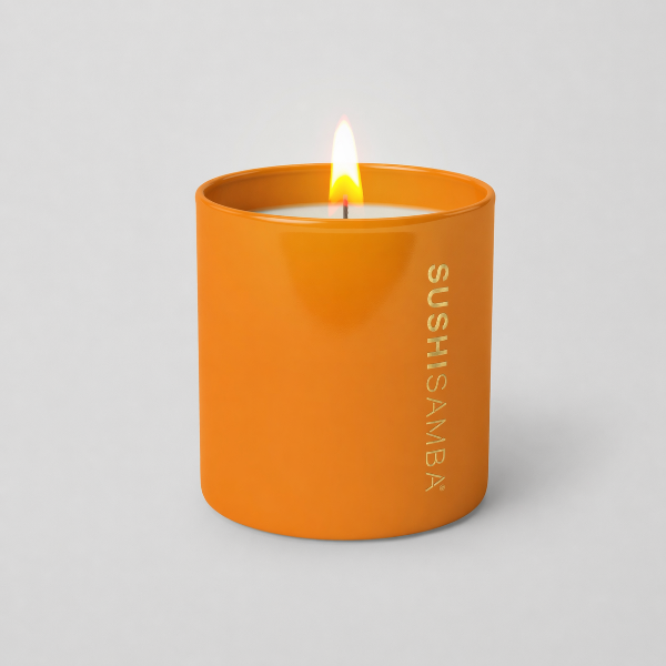 Orange candle with 'Sushisamba' branding on a gray background